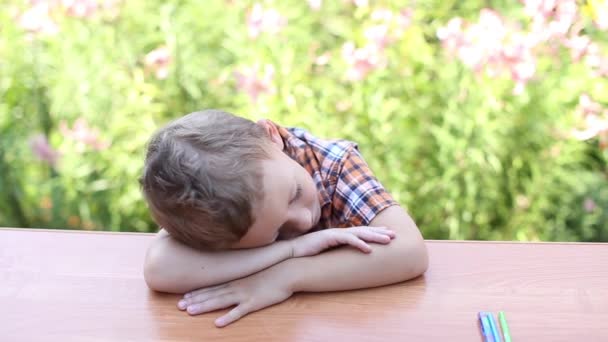 Мальчик спит на столе — стоковое видео
