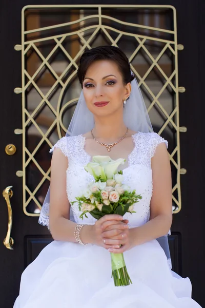 Brunette bruid in een mooie witte jurk — Stockfoto