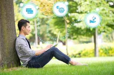 Genç Asyalı ve başarılı işadamı kullanarak tablet, dizüstü, mobil p