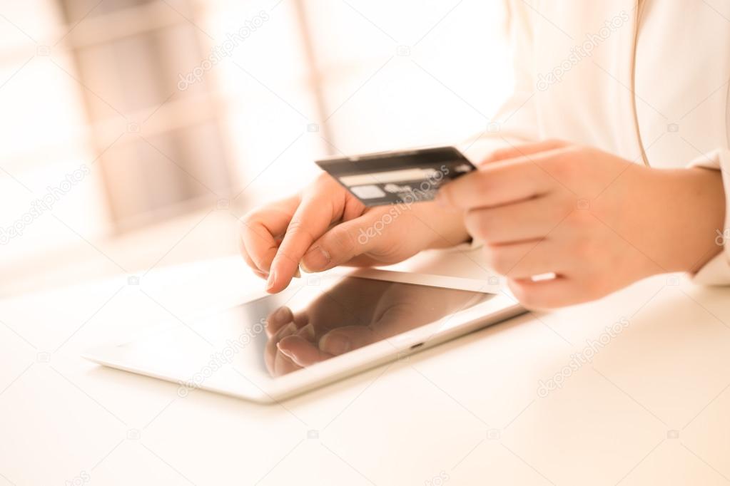 Hands of an office woman typing keyboard with credit card