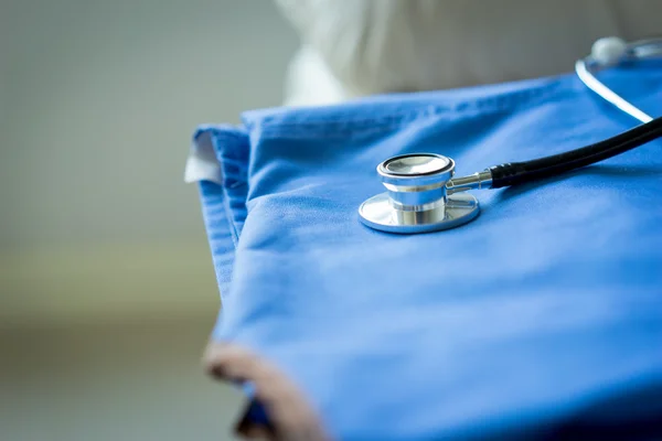 Stetoscopio su infermiere & medico cappotto sfondo — Foto Stock