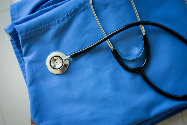 Stetoscopio su infermiere & medico cappotto sfondo — Foto Stock