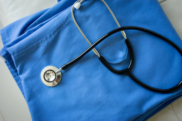 Stetoscopio su infermiere & medico cappotto sfondo — Foto Stock