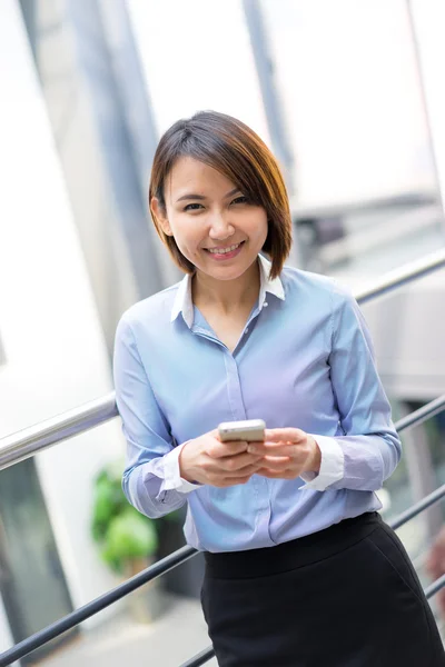 Asiática mujer de negocios hablando en un teléfono móvil en la oficina — Foto de Stock