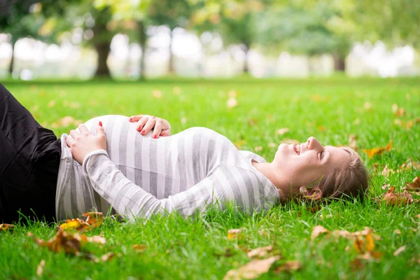 Mulher grávida feliz e jovem no parque no verão Imagem De Stock