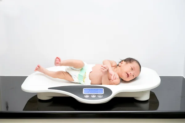 Asya yeni doğan bebek üzerinde ölçekler döşeme