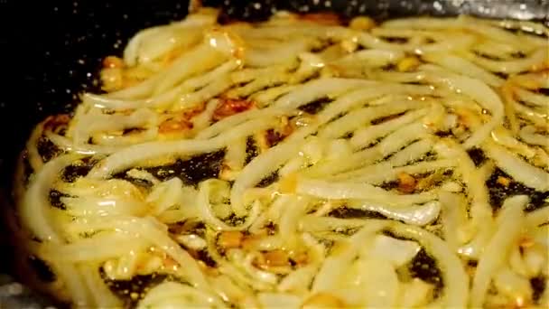 Σοτάρουμε τα κρεμμύδια στο λάδι σε ένα τηγάνι. Αργή κίνηση ζουμ. — Αρχείο Βίντεο