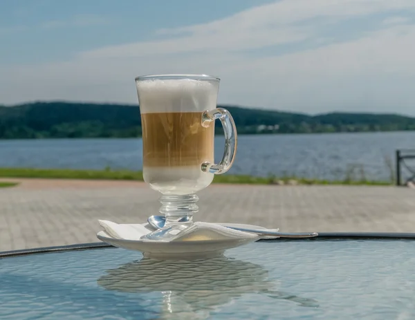 Bir yüksek cam kadeh içinde kahve latte. Doğal zemin üzerine. 