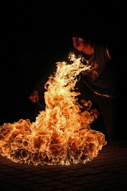 Fire artist performing fire breathing  clipart