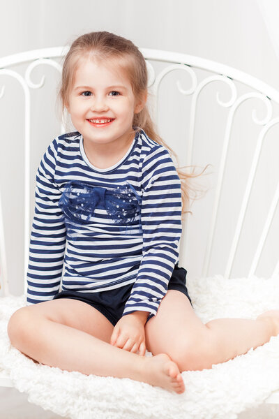 Happy  little girl in striped shirt on white background