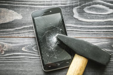 Ahşap rustik arka plan üzerinde kırık ekran ile Smartphone