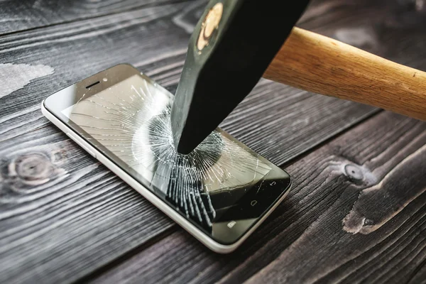 Smartphone mit kaputtem Display auf rustikalem Holzgrund — Stockfoto