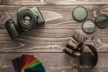 Photo camera on wooden rustic background clipart