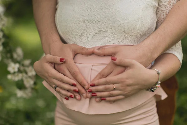 Burta femeii însărcinate cu mâinile soțului ei — Fotografie, imagine de stoc