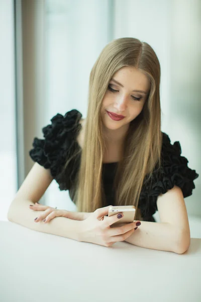 Mulher com telefone na mesa — Fotografia de Stock