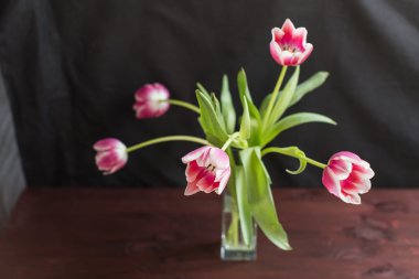 ahşap zemin üzerine vazo içinde Pembe Laleler