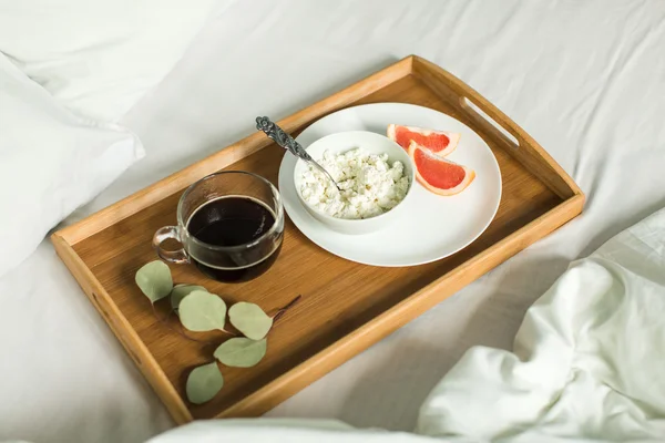 Sarapan sehat di tempat tidur, keju, kopi dan jeruk — Stok Foto