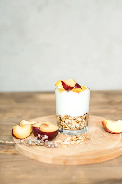 Zdravá snídaně: müsli, cereálie, jogurt s broskví a švestek — Stock fotografie