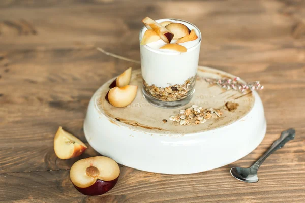 Zdravá snídaně: müsli, cereálie, jogurt s broskví a švestek — Stock fotografie