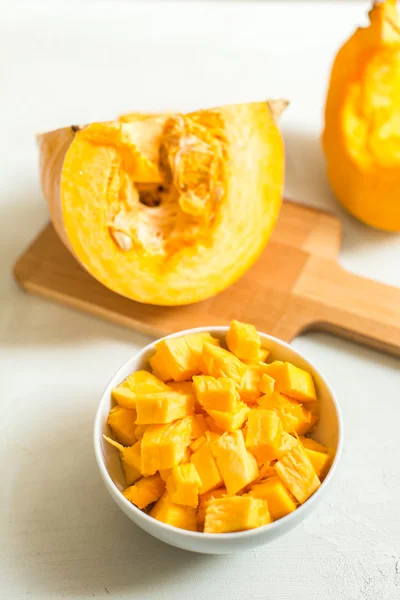 Cocinar sopa de calabaza. trozos de calabaza en un tazón y semillas de calabaza — Foto de Stock