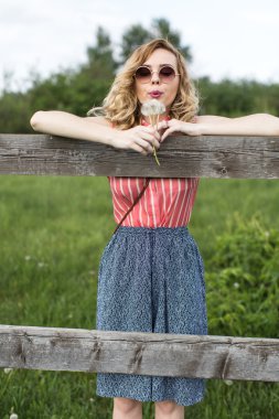 Mutlu genç kadın üfleme karahindiba