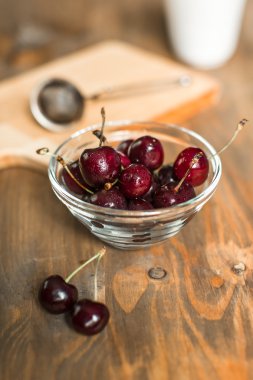 Olgun Kiraz ahşap masa üzerinde cam kapta