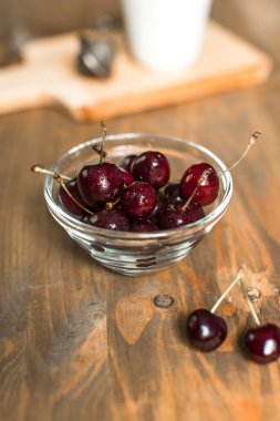 Olgun Kiraz ahşap masa üzerinde cam kapta
