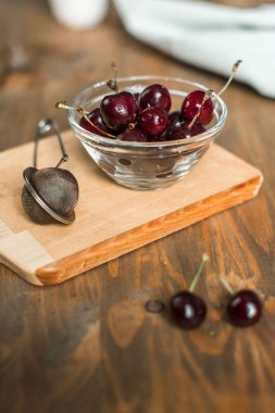 Olgun Kiraz ahşap masa üzerinde cam kapta