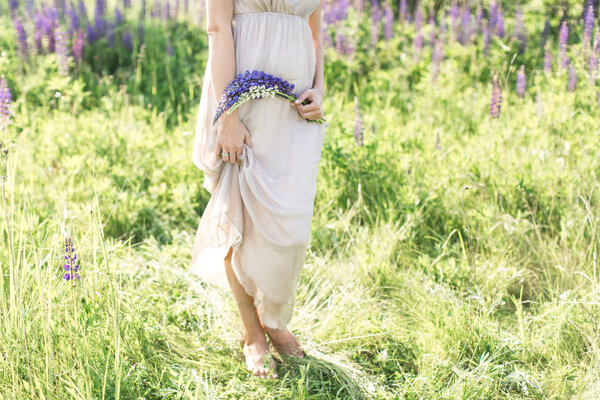 Beautiful young woman in dress with beautiful lupins