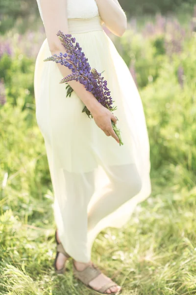 Bella giovane donna in abito giallo con fiore — Foto Stock