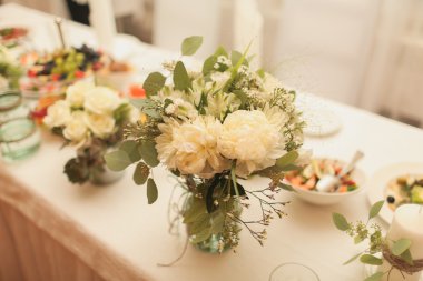 Çiçeklerle süslenmiş düğün masası.