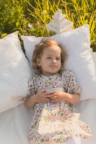 Niña pequeña se acuesta en almohadas —  Fotos de Stock