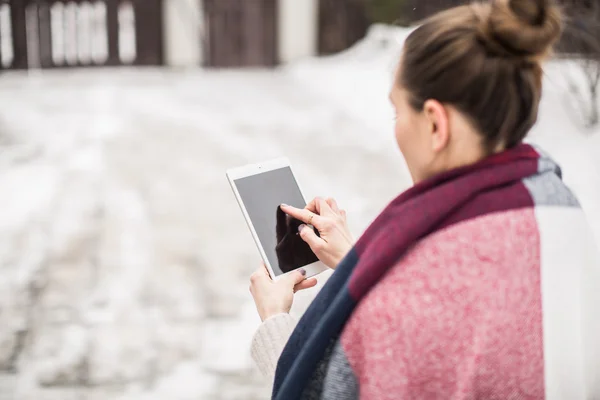 Mujer joven con la tableta en la calle en invierno — Foto de Stock