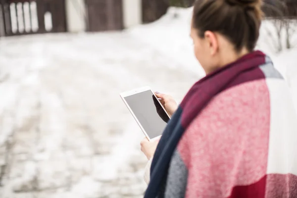Mujer joven con la tableta en la calle en invierno — Foto de Stock