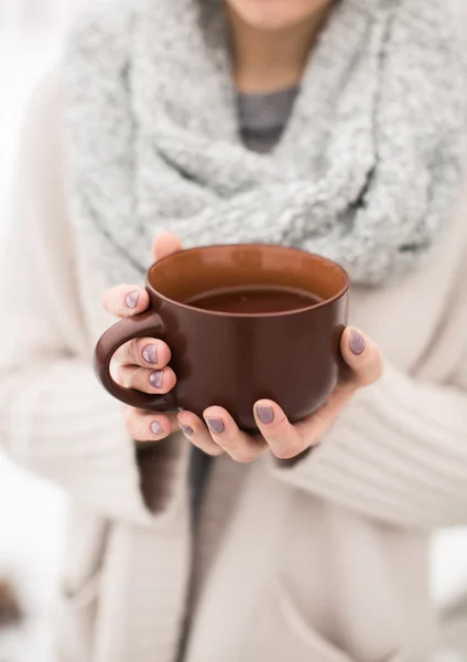 Mãos femininas segurando uma caneca de chá quente — Fotografia de Stock