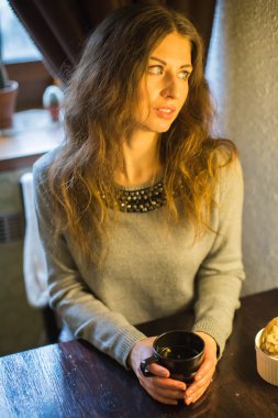 Bir kafede bir masada sıcak çay içme kız