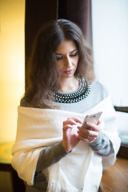 Genç esmer kadın cep telefonla konuşuyor