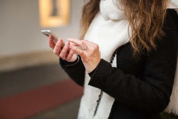 Mädchen hält Telefon in der Hand — Stockfoto