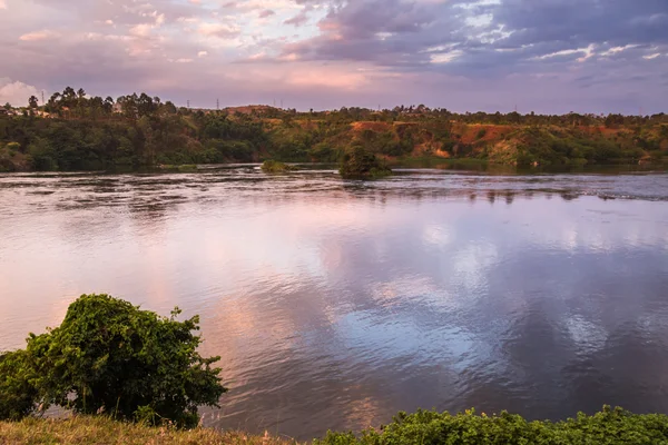 Vista sobre el río Victoria Nilo con isla al amanecer contra el amanecer brillante fondo. Jinja, Uganda . — Foto de Stock