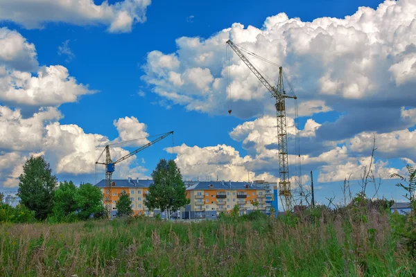 Crane and building construction site against blue sky Royalty Free Stock Photos