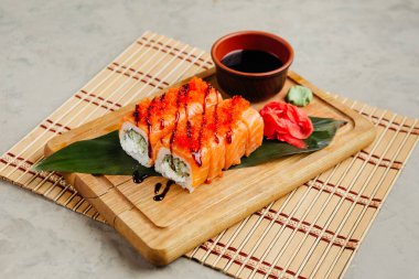 Tahtada soya sosuyla servis edilen balıklı rulo.