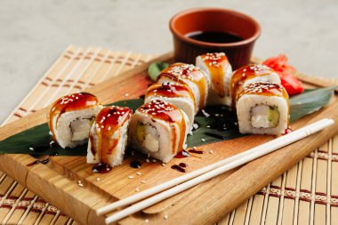 Tahtada soya sosuyla servis edilen balıklı rulo.