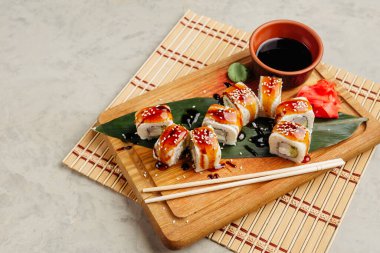 Tahtada soya sosuyla servis edilen balıklı rulo.