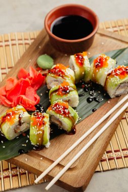 Tahtada soya sosuyla servis edilen balıklı rulo.