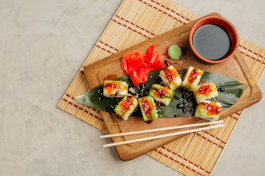 Tahtada soya sosuyla servis edilen balıklı rulo.