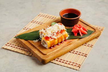 Tahtada soya sosuyla servis edilen balıklı rulo.