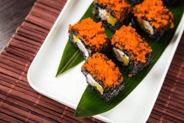 Tahtada soya sosuyla servis edilen balıklı rulo.