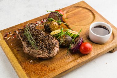 Izgara et ve sebze soslu restoran yemeği.