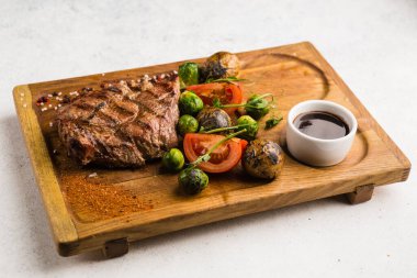 Izgara et ve sebze soslu restoran yemeği.