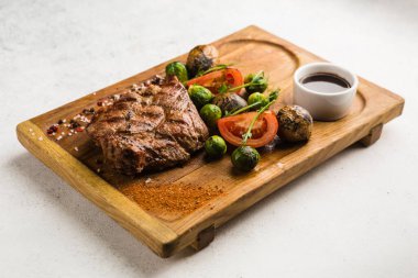 Izgara et ve sebze soslu restoran yemeği.